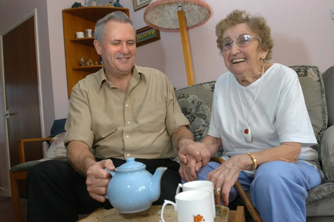 Two people talking over tea during a home visit.